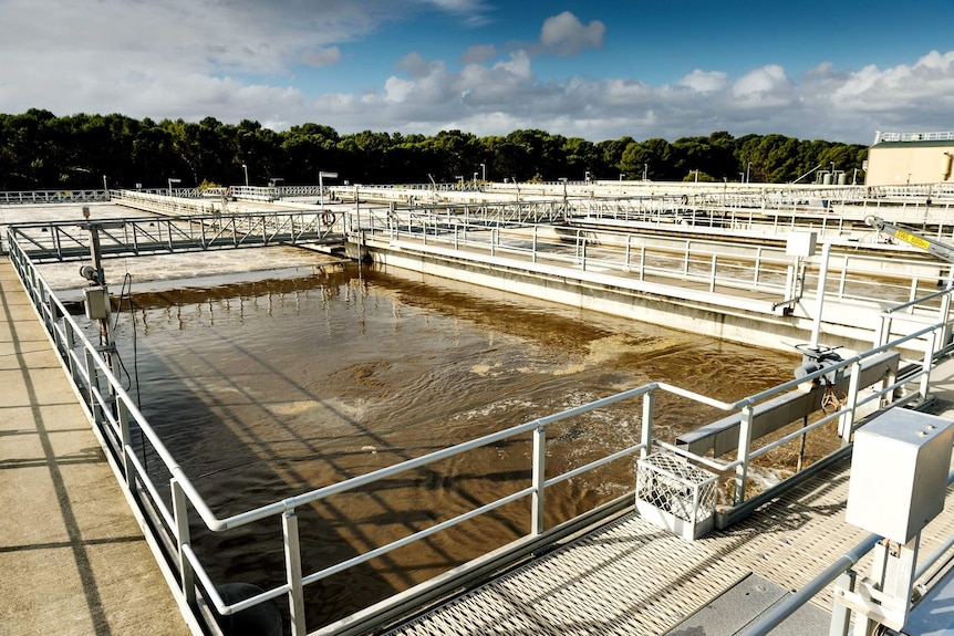 Large outdoor containers of water, bordered by fenced walking platforms at the Bolivar Wastewater Treatment Plant.