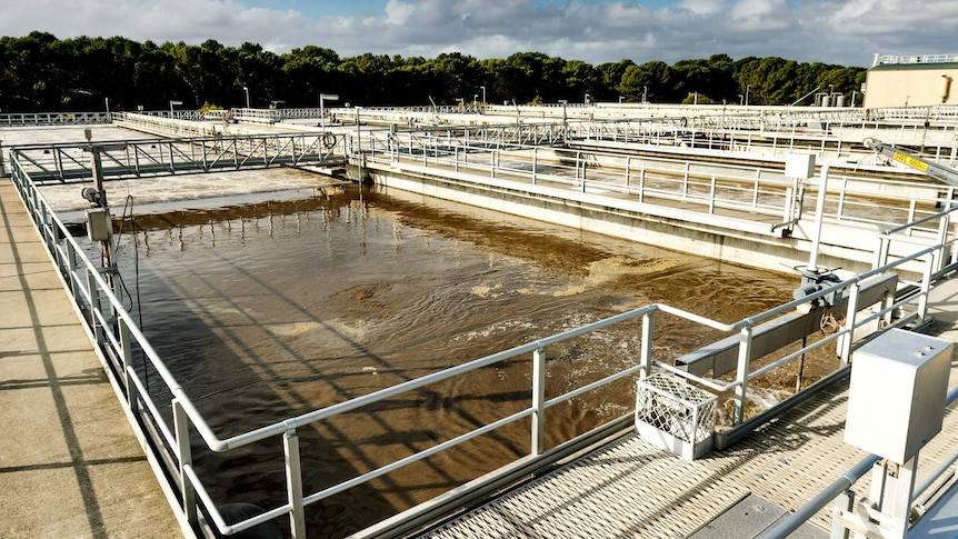 Large outdoor containers of water, bordered by fenced walking platforms at the Bolivar Wastewater Treatment Plant.