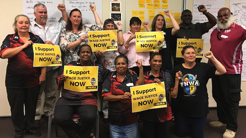 A group of the people holding signs that say "I support wage justice now".