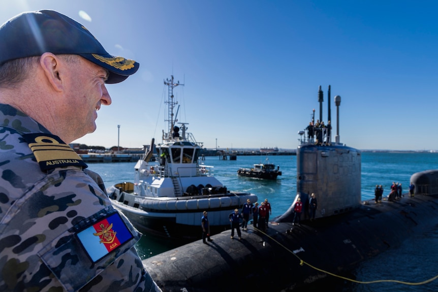Admiral Jonathan Mead watches a Virginia-class submarine on the water. 