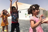 Three young children play in the Zaatari refugee camp.