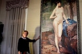 Elaine Madill stands next to a three-metre high painting of a naked woman.