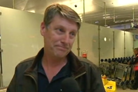 A man being interviewed in an airport.