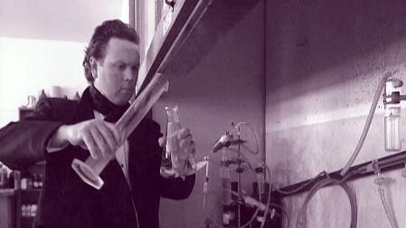 Man holds beakers in laboratory