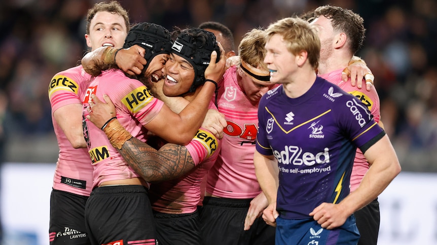 A group of rugby league players celebrate winning a match