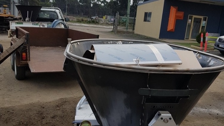 A tub sitting on a trailer which is used to burn waste for biochar