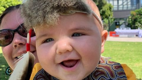 Six-month-old Boston Cox smiles at the camera