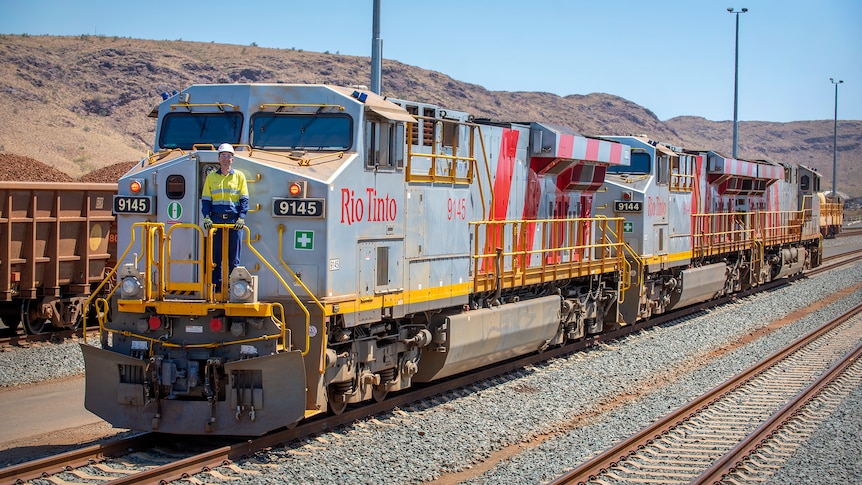 Man standing at front of iron ore train