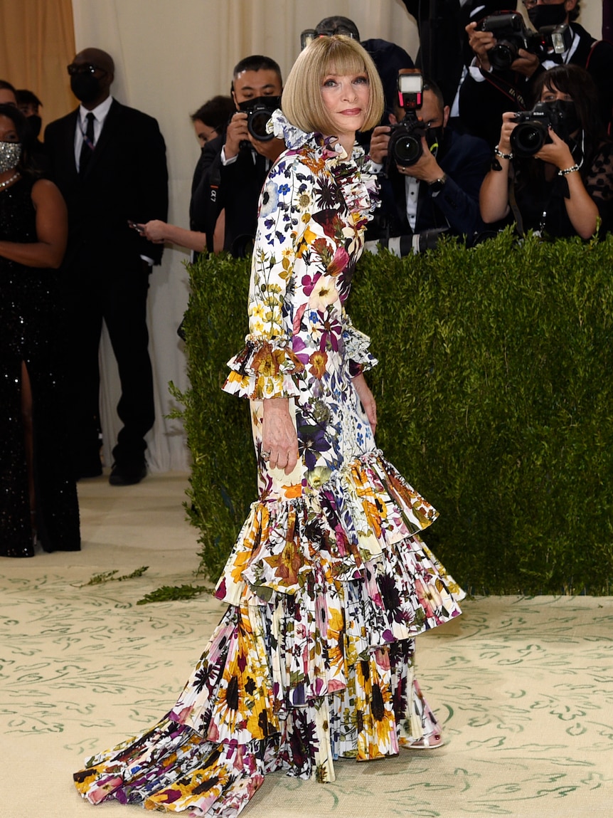 Anna Wintour wears a floral floor-length dress.