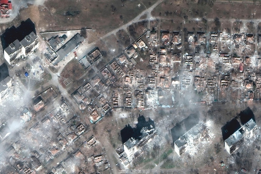 A satellite image shows damaged apartment buildings and homes.