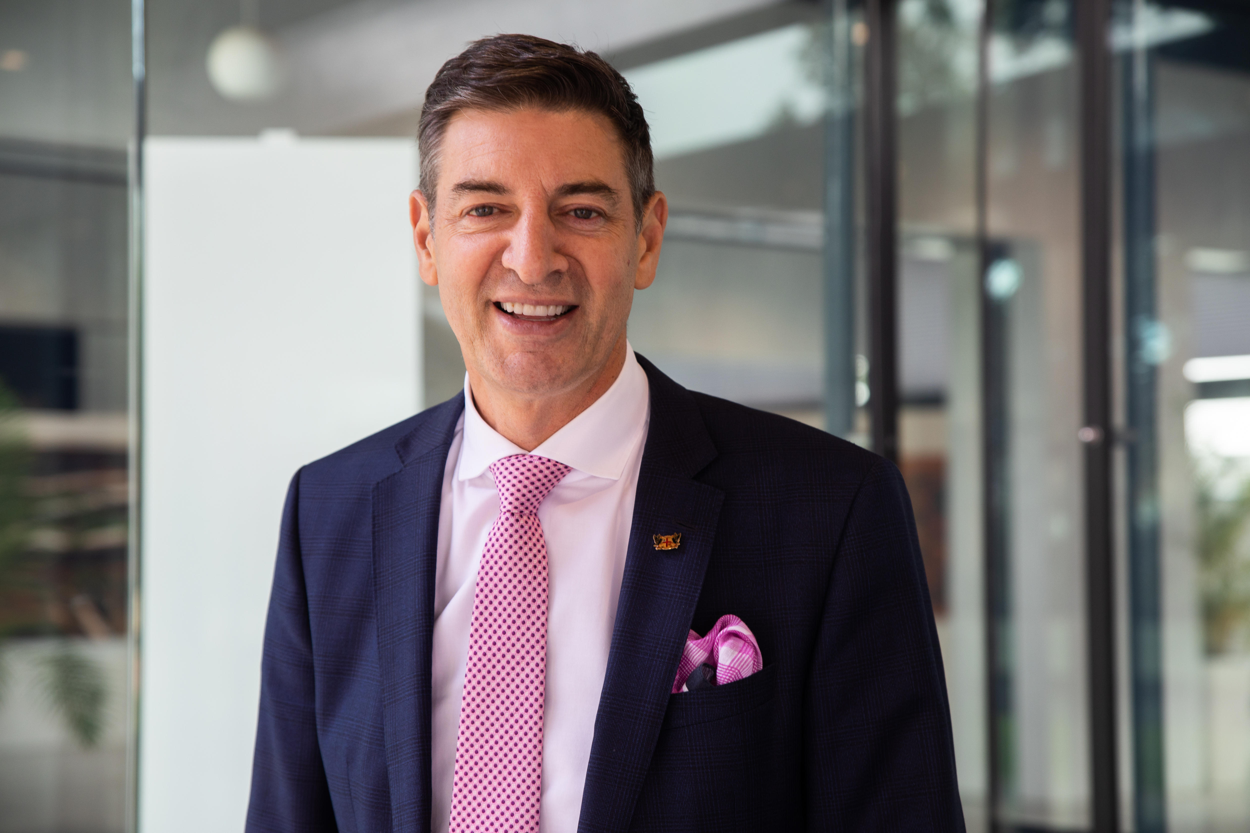 The Lord Mayor wears a navy suit jacket and pink tie