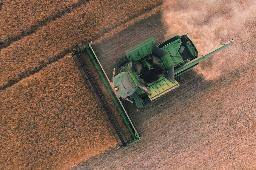 An aerial view of a combine harvester on a crop.