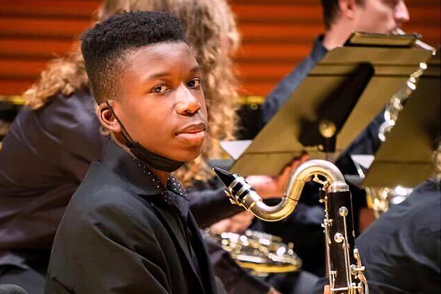16-year-old black teen Ralph Yarl poses for picture while playing bass clarinet in his school band.