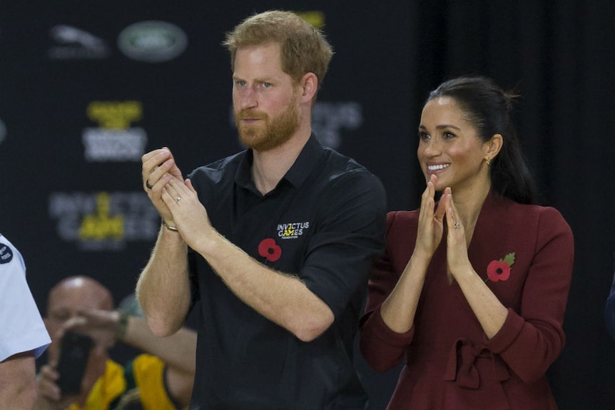 Prince Harry and Meghan in front of a crowd at a basketball game
