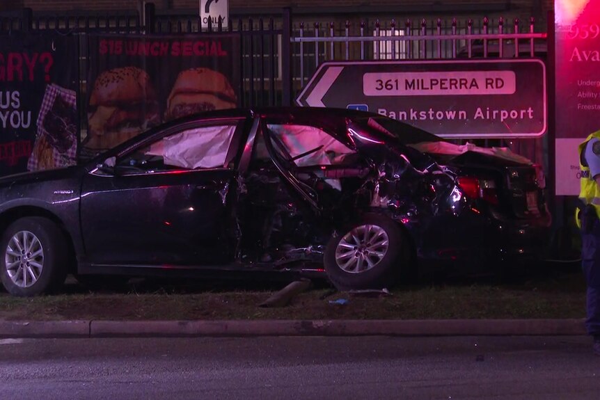 A car following a collision right by a sign that says Milperra road