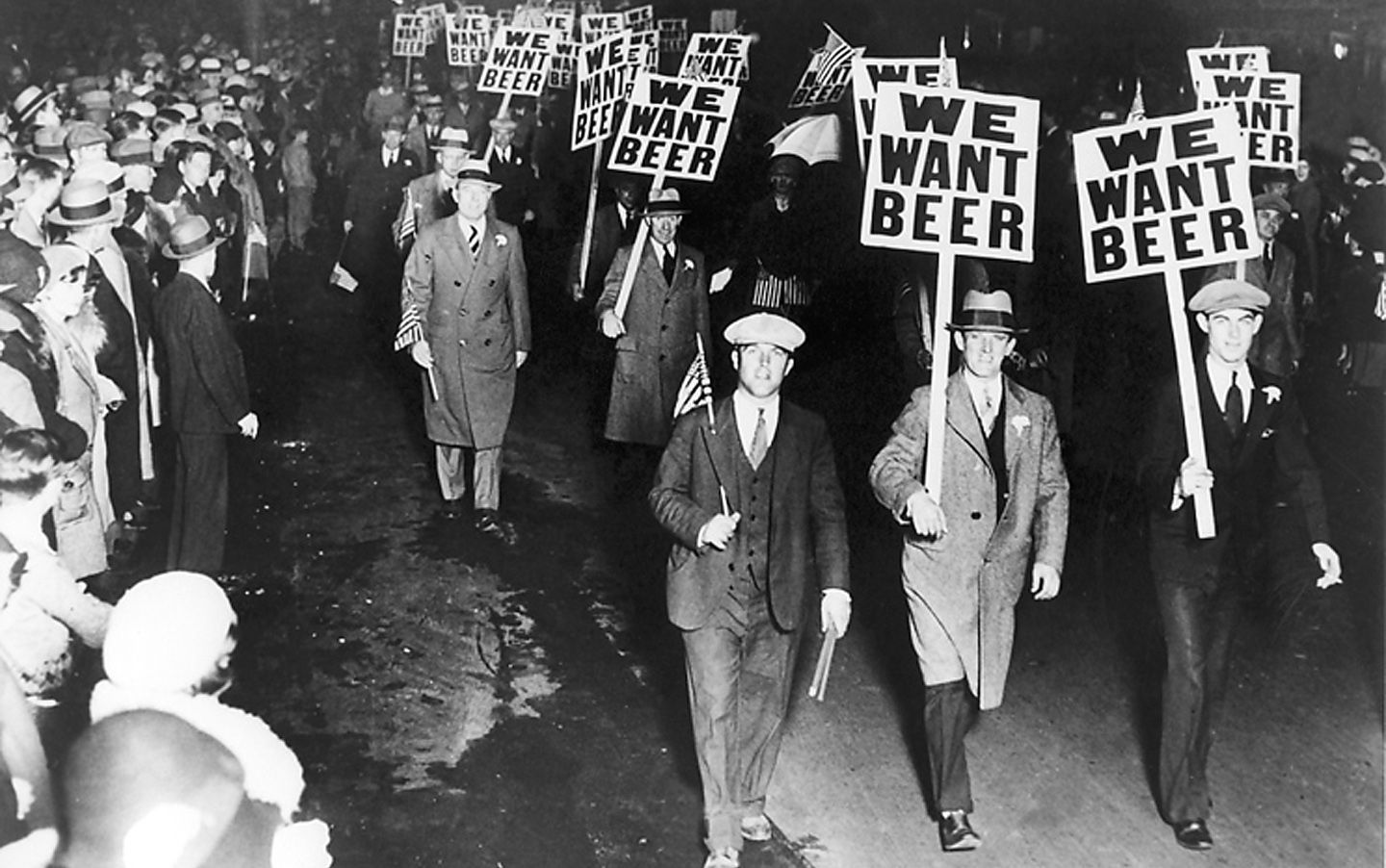 Men march under banners emblazoned with "We Want Beer" on a street in America.