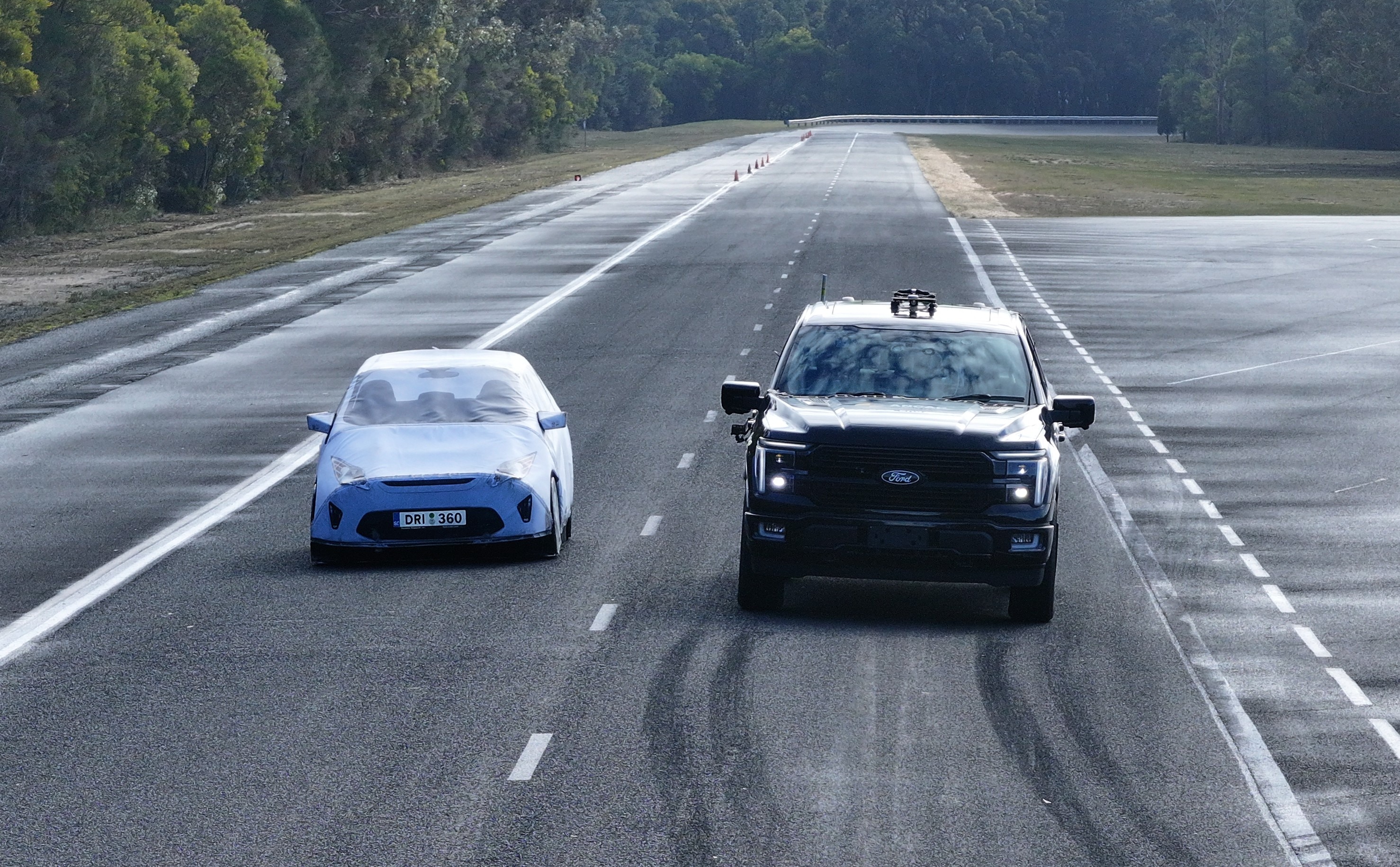 Two vehicles parked alongside each other, one a passenger car, the other a large ute