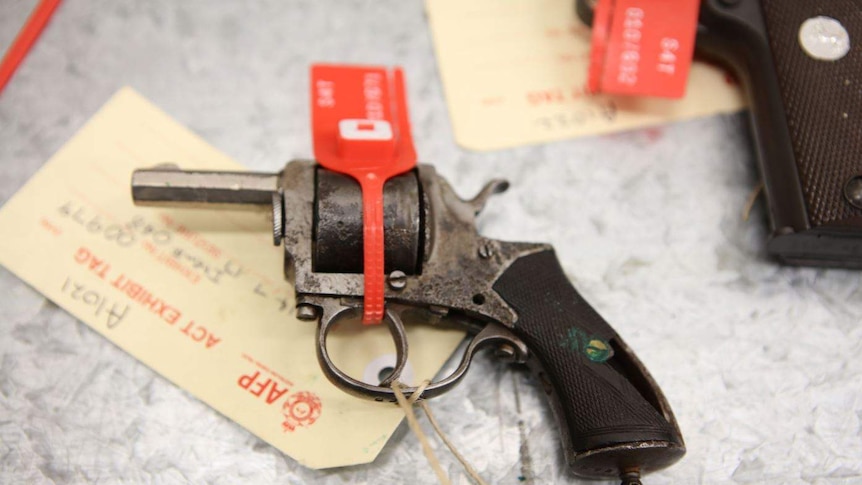 Close-up of an old hand gun with a red tag and ACT Policing exhibit tag attached