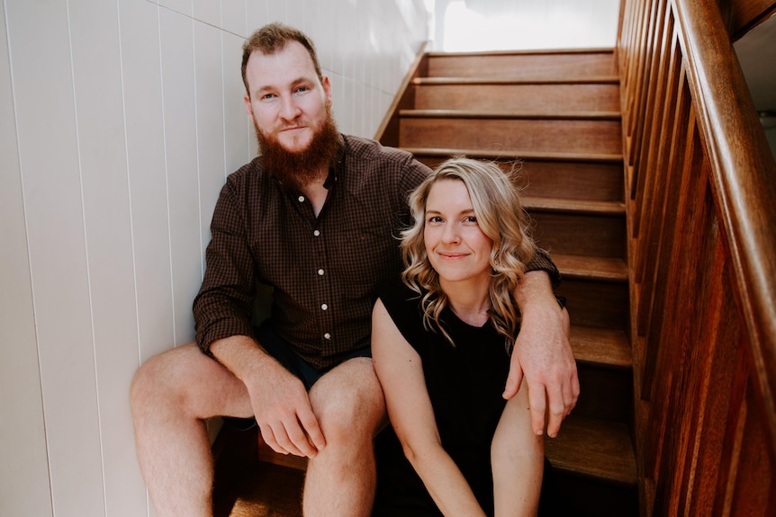 An image of Genevieve Worrell and Lachlan Mackintosh sitting together on stairs.