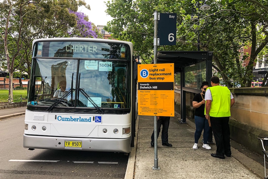 a woman standing next to a bus