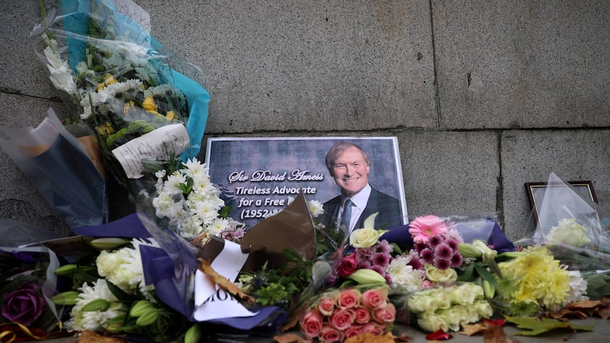 Floral wreaths adorn a photo of British MP David Amess who was killed during a public meeting.