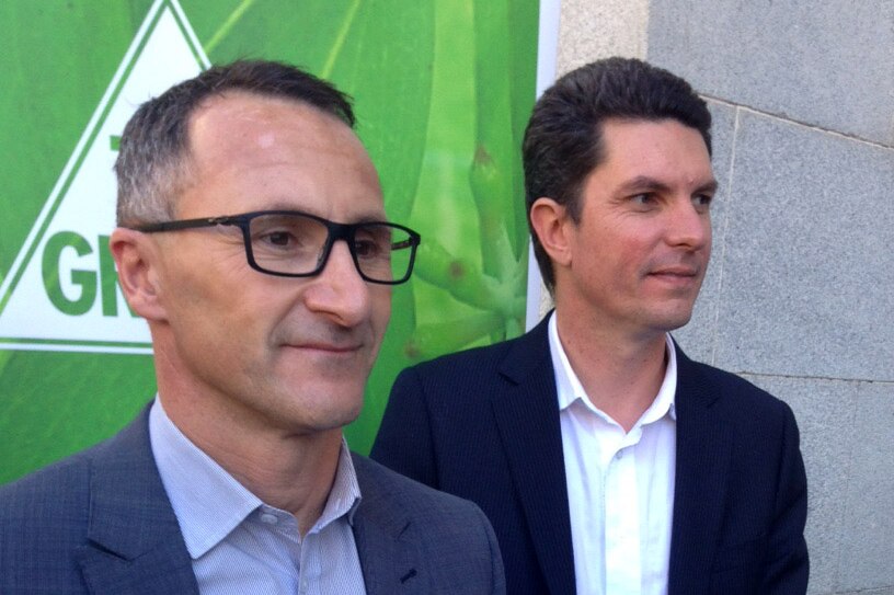 Richard Di Natale (l) with Greens Senator Scott Ludlam in front of a Greens campaign poster.