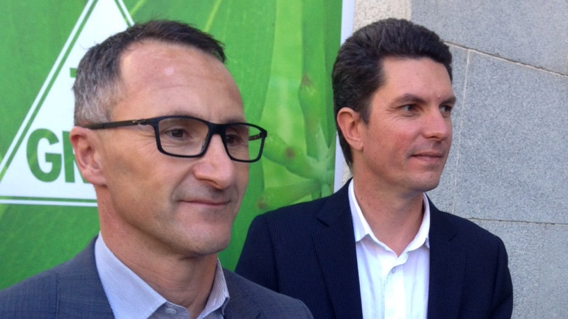 Richard Di Natale (l) with Greens Senator Scott Ludlam in front of a Greens campaign poster.