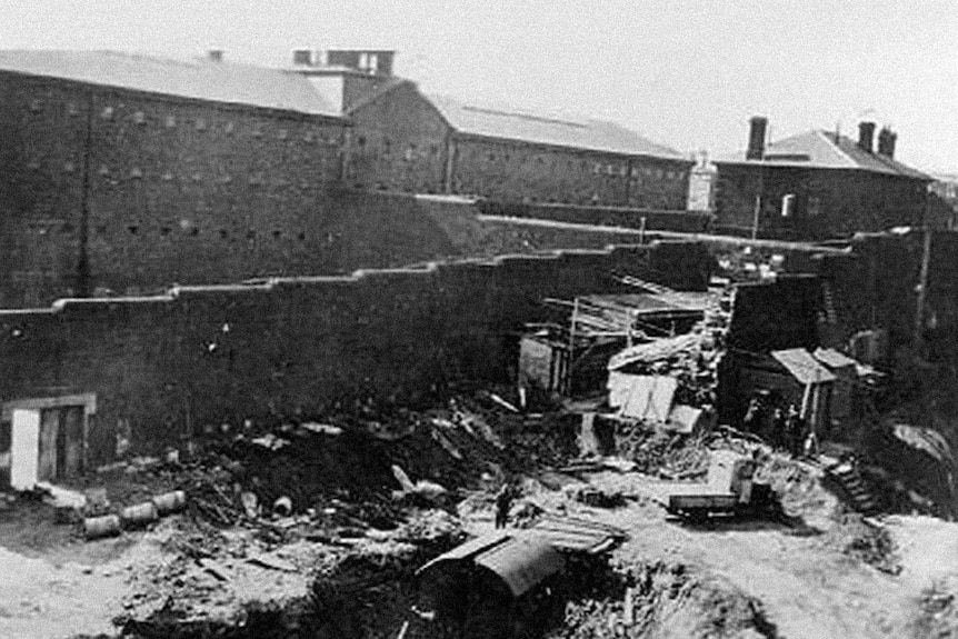 A black and white image of the Old Melbourne Gaol being dismantled in 1929.