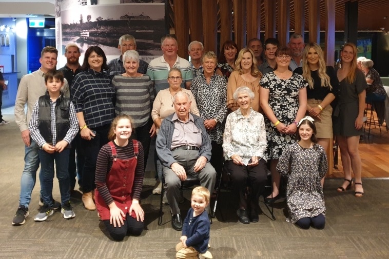 A group of about 20 people including a few children in the foyer of a hotel.