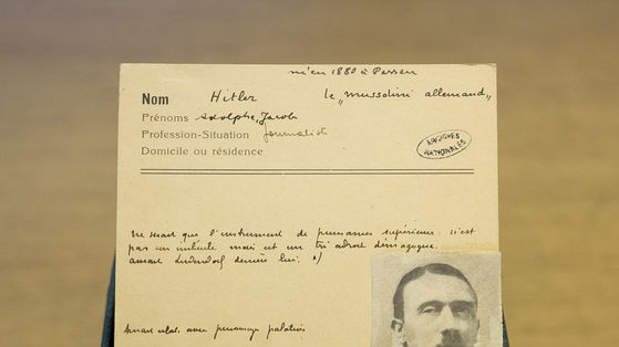 The yellowed hand-written note from 1924 with a photograph of Hitler