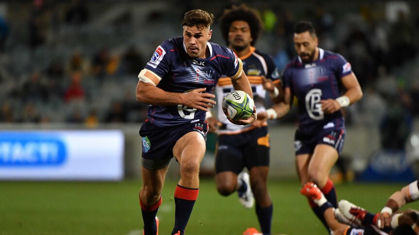 Tom Engish running the ball in his left hand towards the goal line for the Rebels.