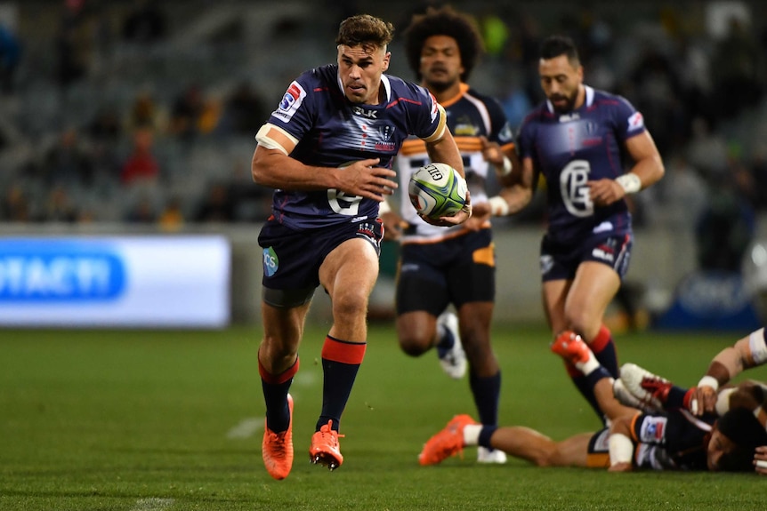 Tom Engish running the ball in his left hand towards the goal line for the Rebels.