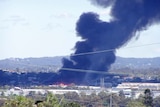 Smoke billows from the warehouse fire in the Brisbane suburb of Sherwood