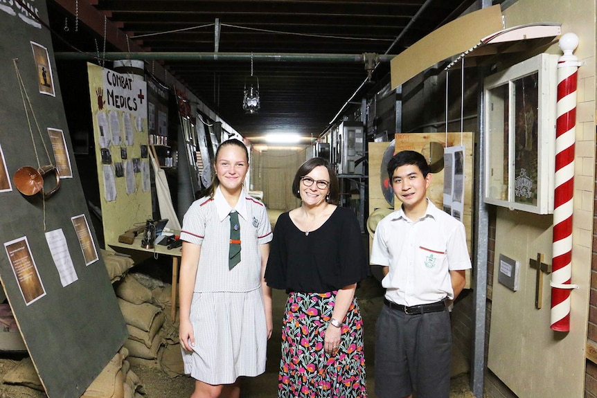 Teacher Kerry Daud stands with two students in the school's replica World War I trench.