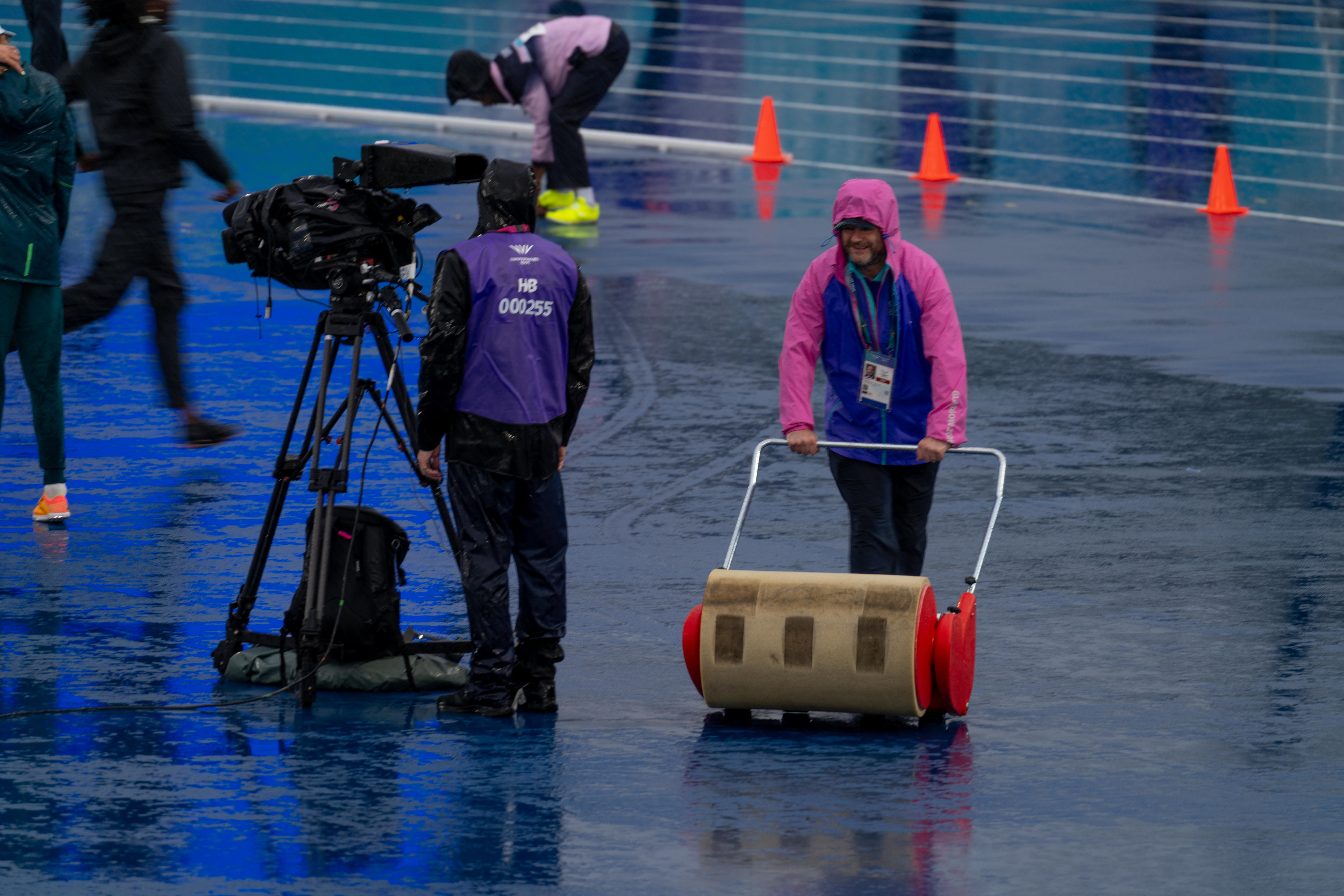 Crews mop up as it rains during the women's high jump final at Scotstoun Stadium.