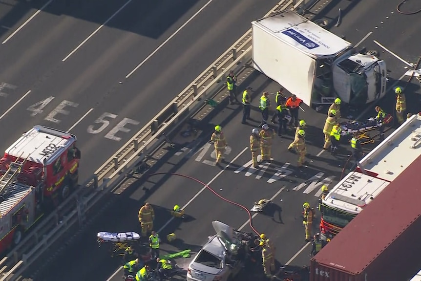 An aerial view of a crash scene on the West Gate Bridge, with a smashed car and truck visible.