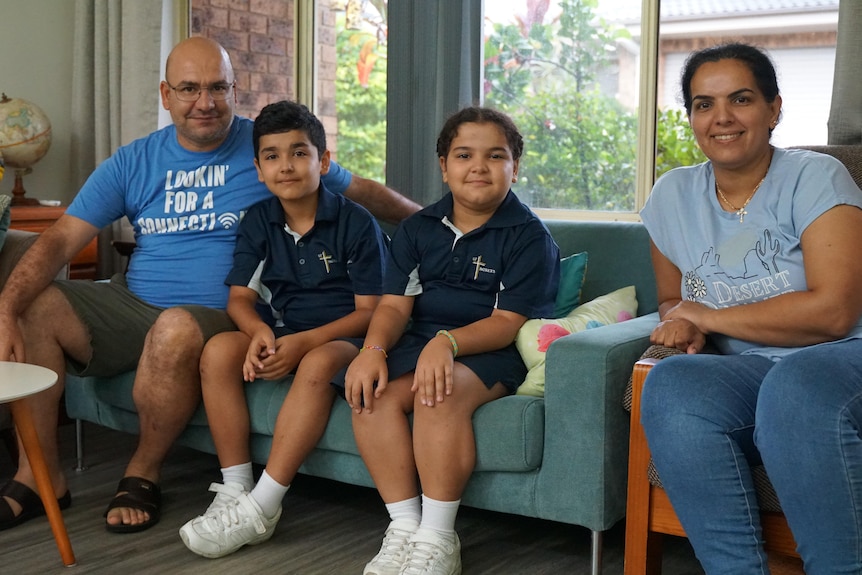 A syrian family sitting on a lounge.