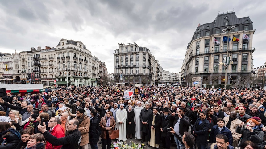 People crowd to stand in silence at the Bourse on the anniversary of the Brussels attacks.