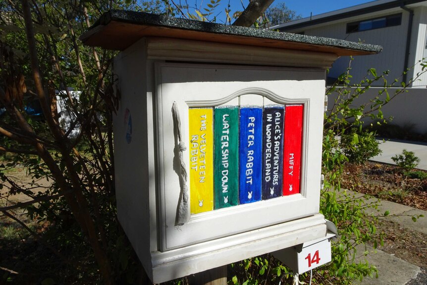 A street library with rabbit-themed books painted on the outside.