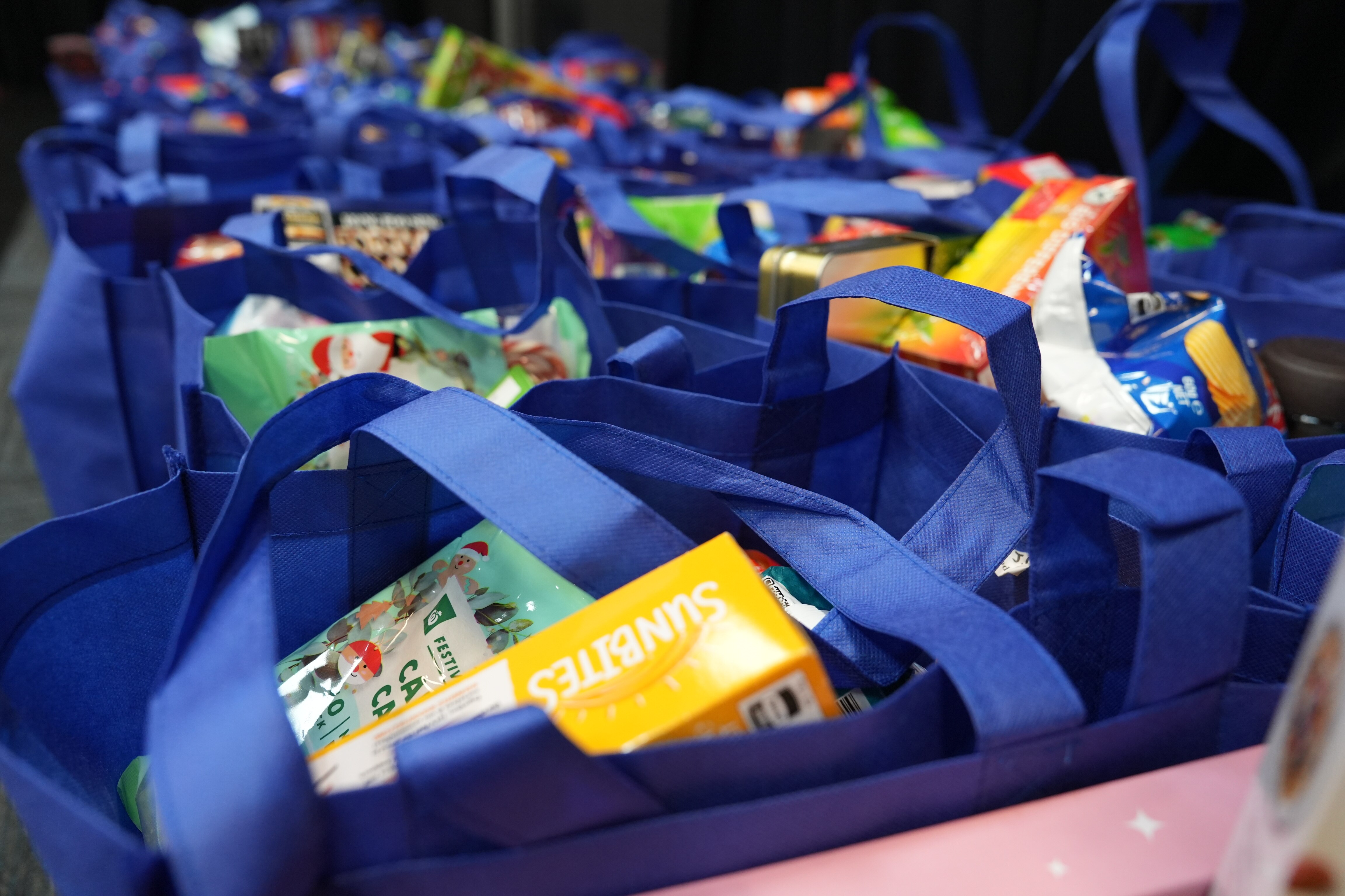 Supermarket goods packed into blue bags 