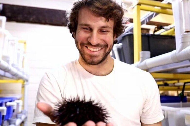 Mitch Gibbs holds a sea urchin