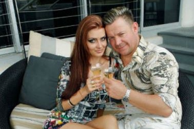 Vitali Roesch and his wife Marnya Kosukhina sitting on a outside couch with champagne in hand.