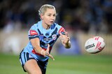 A rugby league player passes the ball in a drill ahead of a Women's State of Origin game.