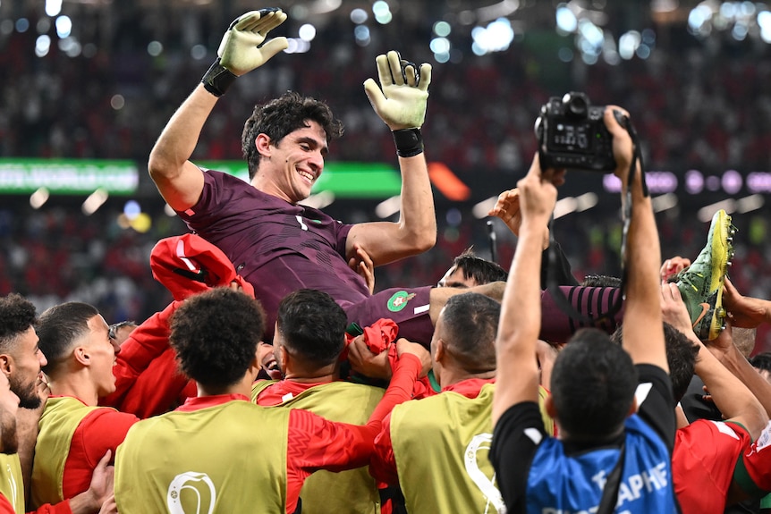 Morocco goalkeeper Yassine Bounou is carried by his teammates after they beat Spain at the Qatar FIFA World Cup.