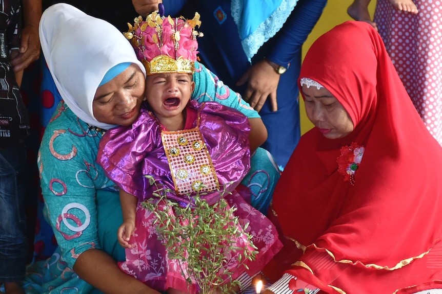 A toddler cries in Gorontalo during a female circumcision story.