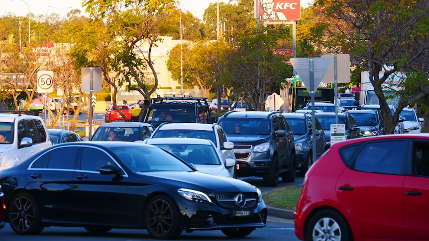 Cars line the road around a roundabout.