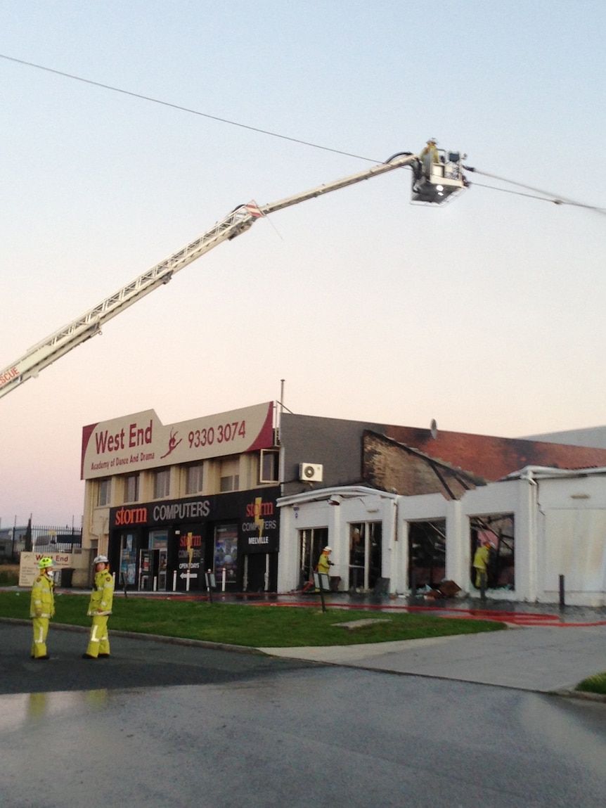 Firefighters outside the gutted SuperCheap Auto