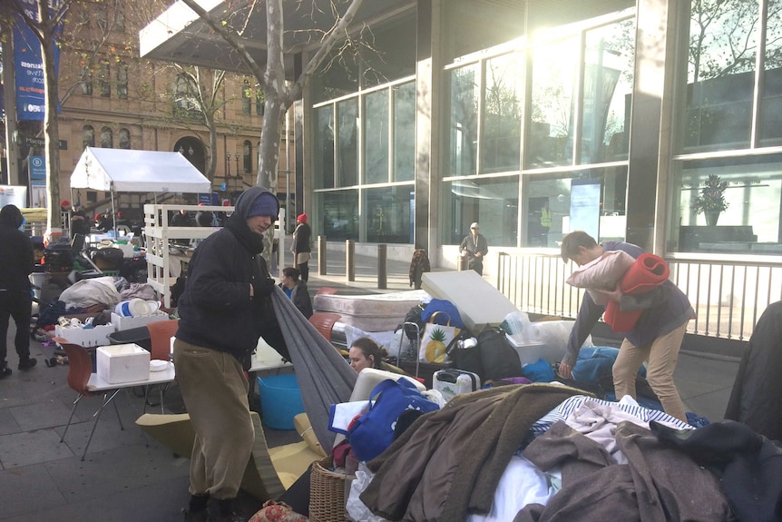 Homeless people in Martin Place  packing up blankets and clothes.
