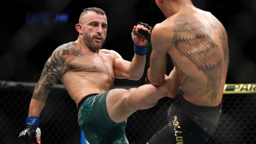 Alexander Volkanovski kicks his opponent, Max Holloway