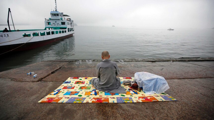 A monk prayers for the missing passengers on board South Korean ferry Sewol at a port at Jindo